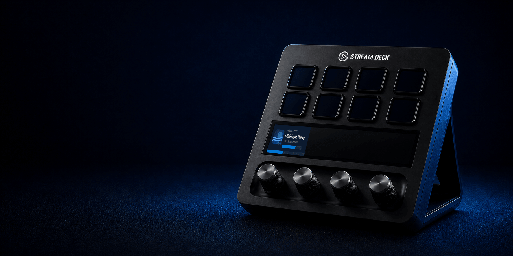 A Stream Deck+ facing left with the Now Playing Windows track view and active media dial